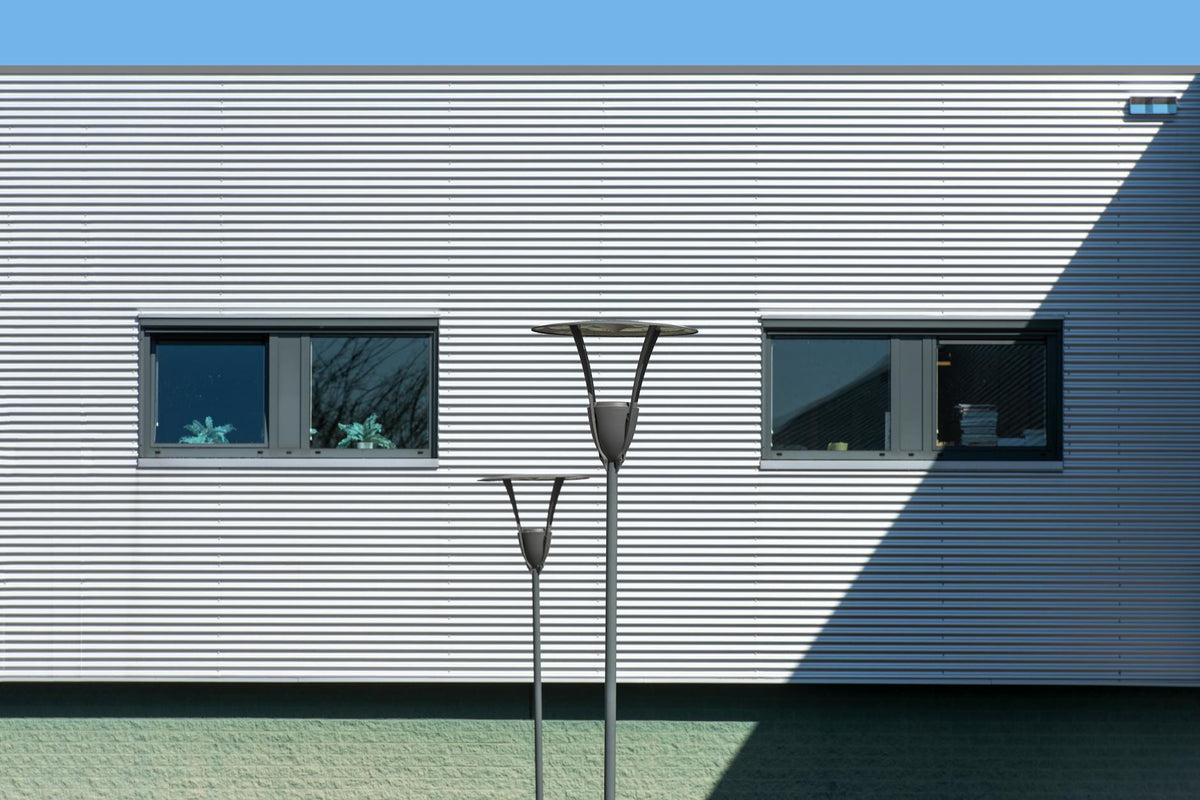 Contemporary building exterior featuring metal facade, windows, and striking shadows.