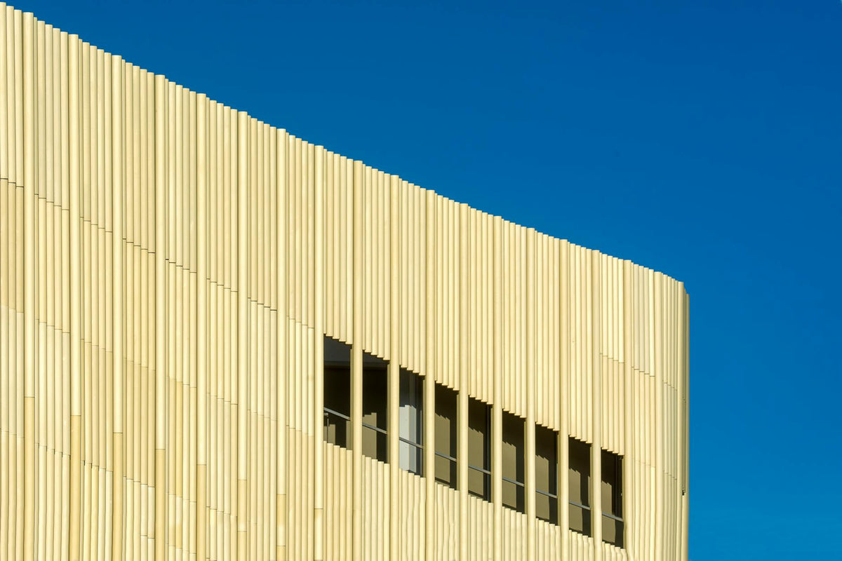Sleek modern architecture with a textured facade under a bright blue sky in Alphen aan den Rijn.