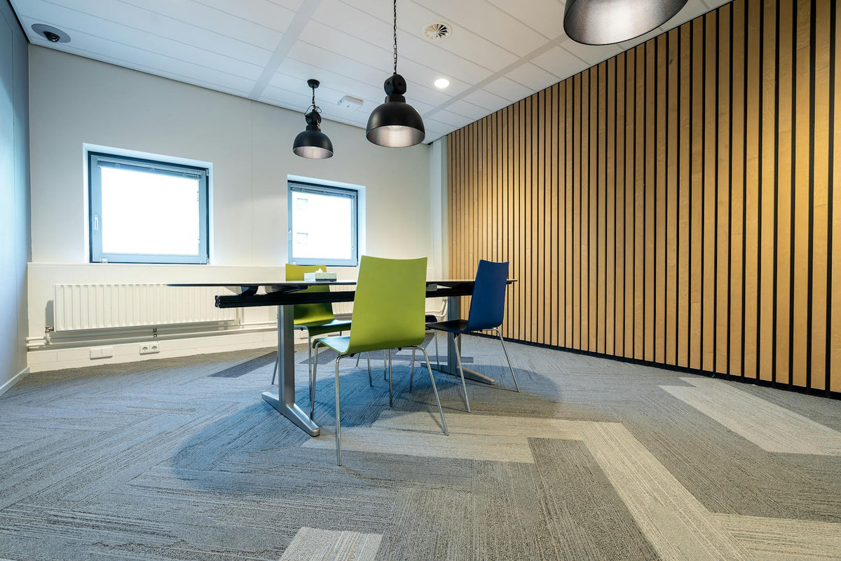 Spacious meeting room with colorful chairs and modern lighting in a corporate setting.