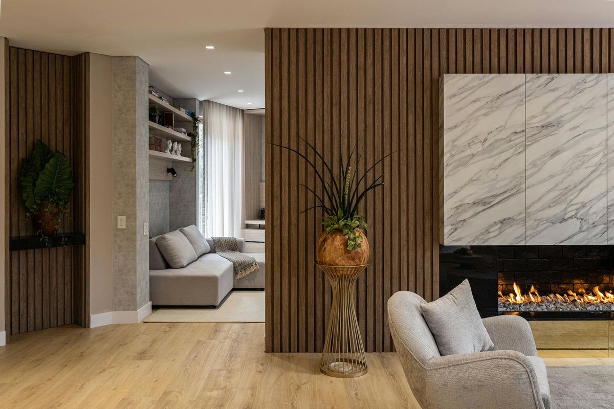 Cozy and stylish living room interior with a marble fireplace, modern furniture, and plants.