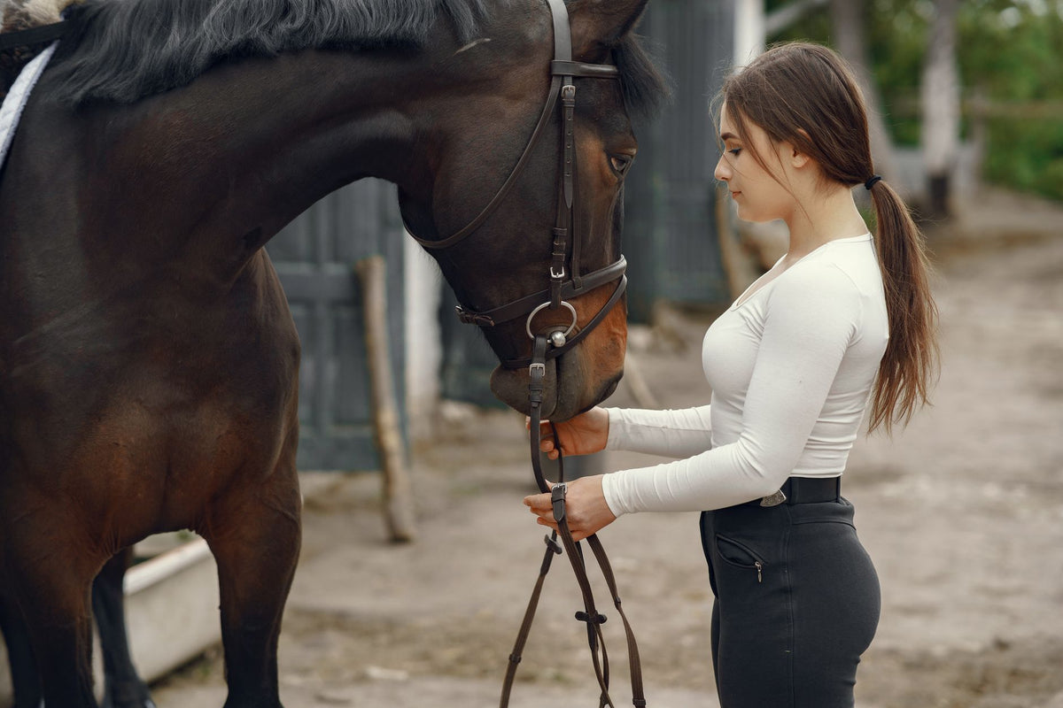 A young woman and her horse share a bonding moment outdoors, showcasing companionship.