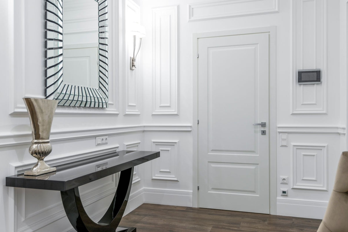 Luxurious white interior with modern decor, featuring a stylish mirror and elegant door.