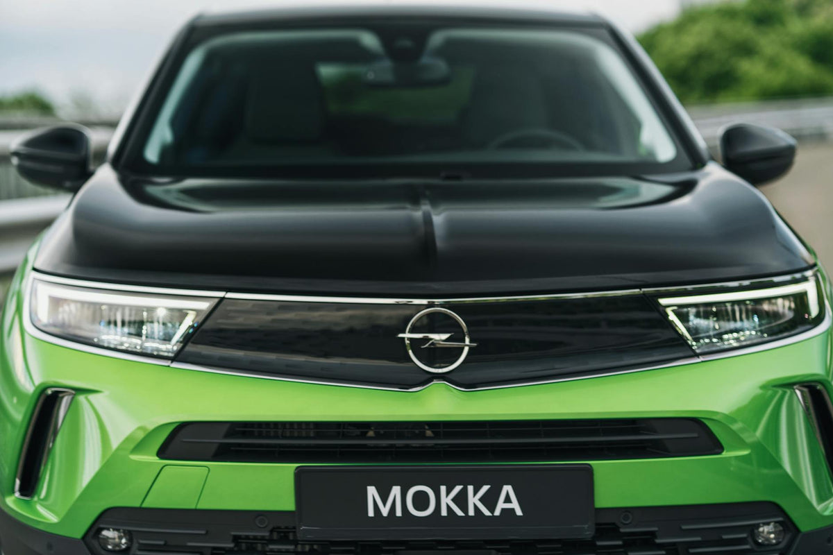 Close-up view of the front of a green Opel Mokka-e electric vehicle.